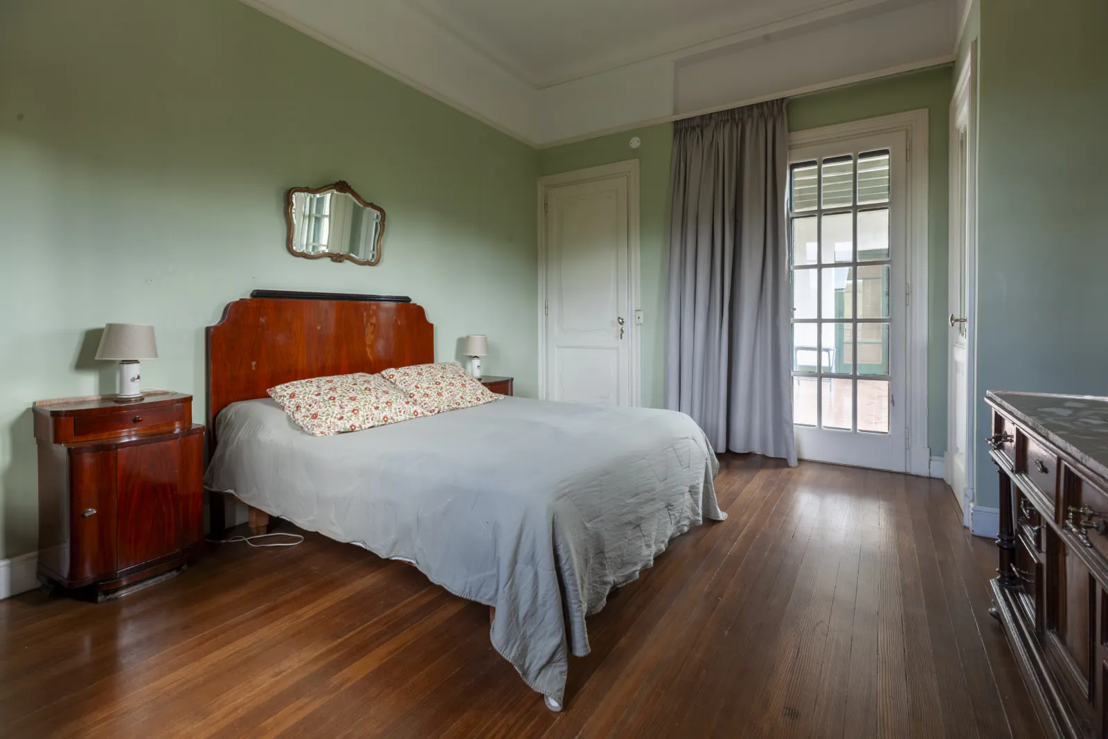 Cuarto María, respaldo de madera y puerta al balcón